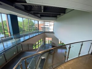 Curved glass stair railing installation at Endicott College by Allstate Glass